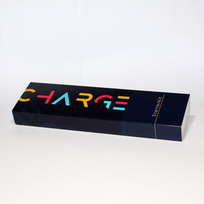 Ein länglicher, dunkelblauer Karton auf dem von links bis zur Mitte in großen gelben, roten und hellblauen Buchstaben "charge" steht. Ganz rechts steht von unten nach oben in weißen Buchstaben "Starterkit". 